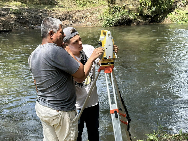 A 探花app engineering student works with a Ecuadorian village to take measurements for a bridge. 